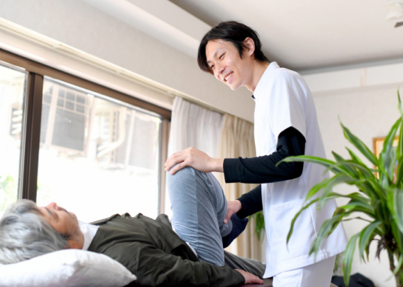 自宅のリビングで施術を受ける男性